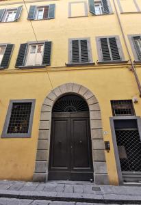 a yellow building with a black door and windows at Casa del Moro in Florence +11 photos