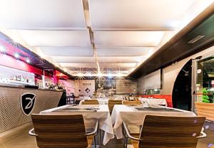 a restaurant with white tables and chairs and a bar at Daytona Business Hotel in Collecchio