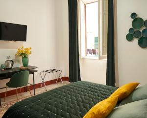 a bedroom with a green bed and a desk and a window at Ballarò Guest House in Palermo