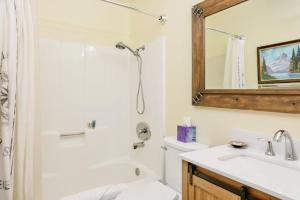 a bathroom with a sink and a toilet and a mirror at Happy Bear #2053 by Big Bear Vacations in Big Bear Lake +12 photos