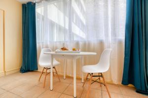- une table et des chaises dans une chambre avec fenêtre dans l'établissement Paris 16 Studio cosy Tour Eiffel Auteuil, à Paris