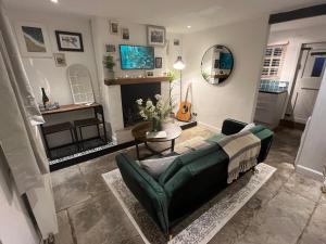 sala de estar con sofá verde y mesa en Bay Cottage, Hot Tub, en Snitterfield