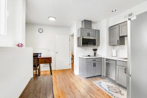 uma cozinha com armários brancos e piso em madeira em Ballard Bliss Studio em Seattle