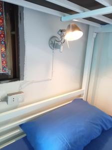 a room with a blue bed and a light and a window at TIKI HOSTEL in Haad Rin