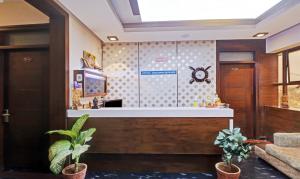 a lobby with a reception counter with plants at Treebo Trend RJ Residency in Mysore
