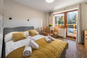 1 dormitorio con 2 camas y toallas. en Willa Regle, en Zakopane
