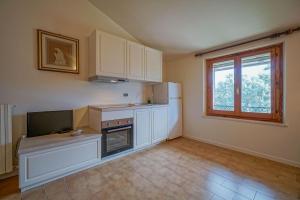 a kitchen with white cabinets and a television in it at Il Quercione Agriturismo in Rivotorto