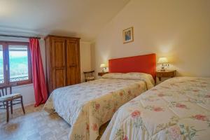 een slaapkamer met 2 bedden en een raam bij Il Quercione Agriturismo in Rivotorto 