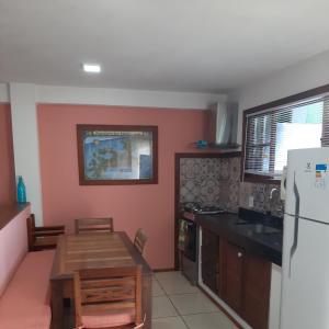 a kitchen with a table and a refrigerator at Buzios Casa 2 in Búzios