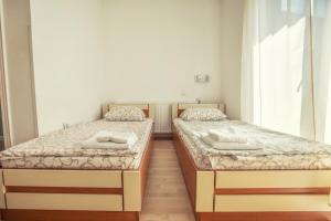 two twin beds in a room with a window at ADICA PRENOĆIŠTE SPORT Wellness centar - bazeni in Ada