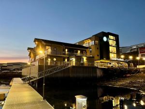 un bâtiment éclairé dans une ville la nuit dans l'établissement Arctic Sea Hotel, à Hammerfest