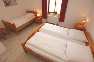 2 Betten in einem Zimmer mit 2 Lampen an Tischen in der Unterkunft Rössle Apart FeWo in Friedenweiler