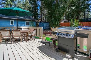 een patio met een grill en een tafel met stoelen en een parasol bij Kitkats Hideaway-1874 by Big Bear Vacations in Big Bear Lake