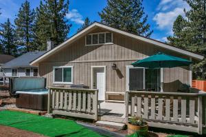 een klein huis met een terras en een paraplu bij Kitkats Hideaway-1874 by Big Bear Vacations in Big Bear Lake