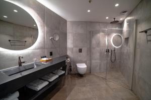 a bathroom with a sink and a toilet and a shower at Sorrisniva Arctic Wilderness Lodge in Alta