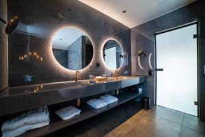 a bathroom with two sinks and a large mirror at Sorrisniva Arctic Wilderness Lodge in Alta