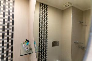 a bathroom with a shower and a toilet and a sink at Dafni Plus Hotel in Leptokarya