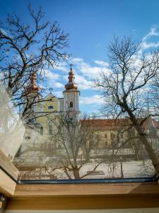 a view of a building with a tower and trees at The Nest Baia Mare in Baia Mare