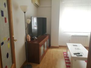 a living room with a flat screen tv on a cabinet at Luminoso, tranquilo in Aranjuez +4 photos