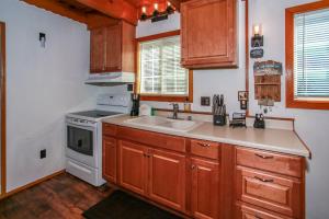 a kitchen with wooden cabinets and a sink and a stove at Palms To Pines-1877 by Big Bear Vacations in Sugarloaf