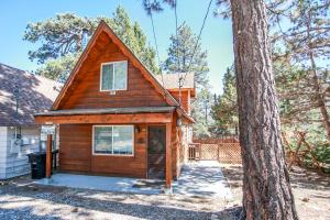 a small cabin in the woods next to a tree at Palms To Pines-1877 by Big Bear Vacations in Sugarloaf