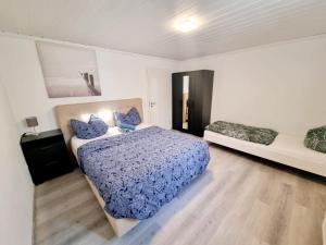 a bedroom with a bed with blue sheets and a window at RELAX Wohnung Groß Rohrheim in Groß-Rohrheim