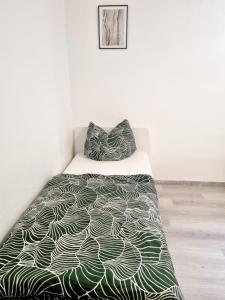 1 dormitorio con 1 cama con edredón verde y blanco en RELAX Wohnung Groß Rohrheim, en Groß-Rohrheim