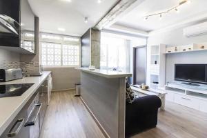 kuchnia z salonem z kanapą i telewizorem w obiekcie Cerca de Picasso y la Merced, Apartamento renovado w Maladze