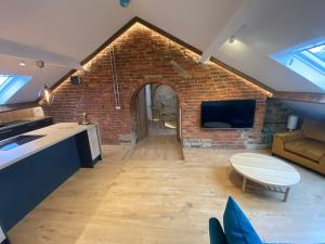 cocina y sala de estar con pared de ladrillo en The Loft @3 en Barnsley