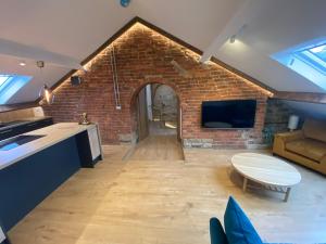 a kitchen and living room with a brick wall at The Loft @3 in Barnsley