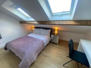 um quarto com uma cama, uma secretária e uma cadeira em The Loft @3 em Barnsley