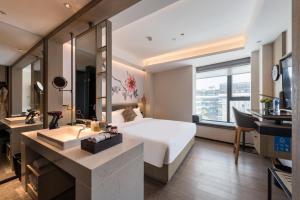 una camera d'albergo con un letto e un lavandino di Paco Hotel Canton Tower Pazhou a Canton