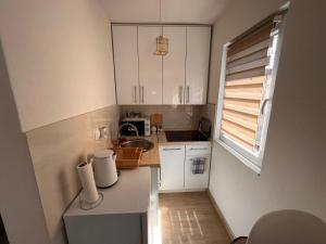a small kitchen with white cabinets and a sink at City apartment 2 in Visoko