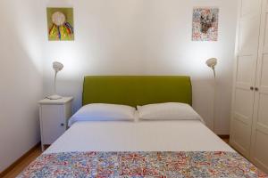 a bed with a green headboard in a bedroom at Agora Apartments -Friend's House Sorrento in Sorrento