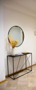 un jarrón en una mesa con un espejo en la pared en Casa Clarissa, en Merano