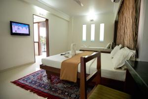 Säng eller sängar i ett rum på Hotel Sai Sangam