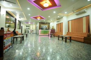 a lobby with couches and tables in a building at Hotel Sai Sangam in Shirdi