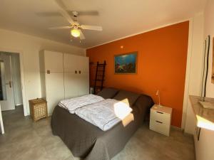 a bedroom with a bed and an orange wall at Anfora MitoMare in Grado