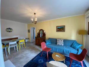 a living room with a blue couch and chairs at Anfora MitoMare in Grado
