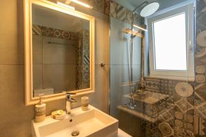 a bathroom with a sink and a mirror and a shower at Vakakis Family Luxury Studios in Palaiochóra +56 photos