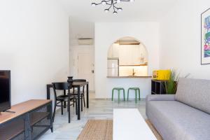 uma sala de estar com um sofá e uma mesa em LU&CIA THYSSEN CITY CENTER em Málaga