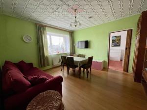 a living room with a couch and a table with chairs at Mājīgs dzīvoklis Salacgrīvā in Salacgrīva