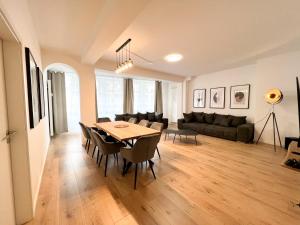 a dining room and living room with a table and chairs at Centerapartments Premium DeLuxe in Düsseldorf