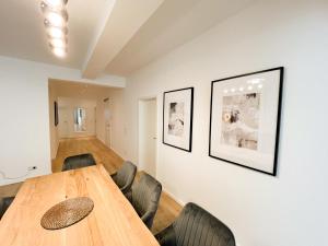 a dining room with a wooden table and chairs at Centerapartments Premium DeLuxe in Düsseldorf