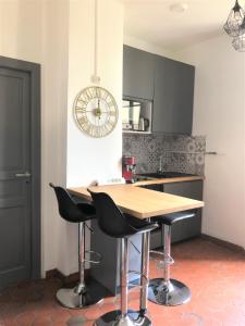 a kitchen with a wooden table and black bar stools at Côté Cour Lyon Part Dieu in Lyon