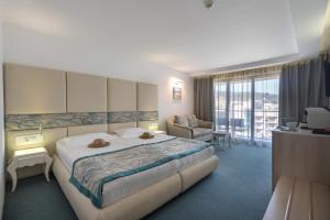 Habitación de hotel con cama y sala de estar. en GRIFID Metropol Hotel - Premium All inclusive & Private Beach - Adults Only, en Golden Sands