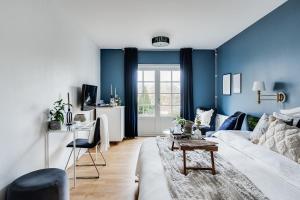 sala de estar con sofá blanco y paredes azules en Pensionat Enehall, en Båstad