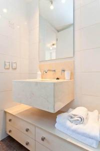a bathroom with a white sink and a white towel rack at Departamentos Costa Nueva de Lyon in Santiago