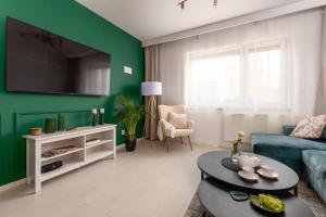 a living room with a green accent wall at Magic Place - Francuska Park in Katowice