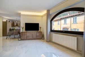 a living room with a large window and a flat screen tv at Appartamento Golfo di Solcio in Lesa